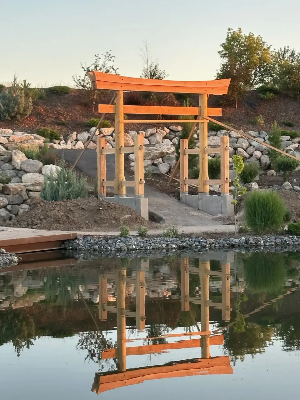 Timber pavilion structure beside a reflecting pool